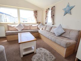 A living room with a sofa and a coffee table at Willerby Aurora B14 in Towyn