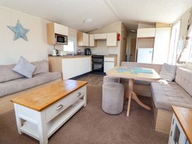 A living room with kitchen area and seating at Willerby Aurora B14 Towyn