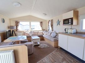 A living room with a sofa and dining table at Willerby Aurora B14 in Towyn