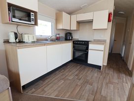 A kitchen with appliances and counter space at Willerby Aurora B14 Towyn