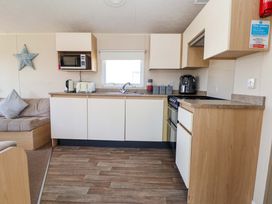 A kitchen with appliances and cabinets at Willerby Aurora B14 Towyn