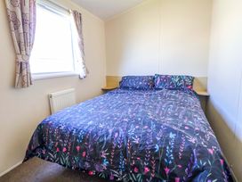 A bedroom with a bed and window at Willerby Aurora B14 Towyn