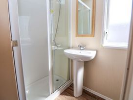 A bathroom featuring a shower, sink, mirror and window at Willerby Aurora B14 Towyn