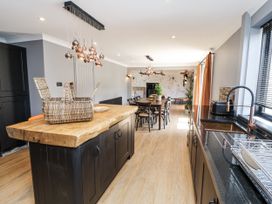 A kitchen with a wooden island and dining area at Holly Farm near Brantham