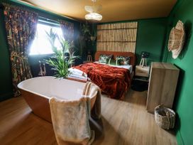 A bedroom with a bed and a bathtub at Holly Farm near Brantham