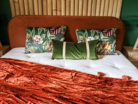 A bed with decorative pillows and a blanket at Holly Farm and Annexe near Brantham