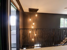 A hallway with lights and a view into a bathroom at Holly Farm near Brantham