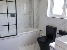 A bathroom with a bathtub and toilet at Holly Farm near Brantham