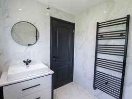 A bathroom with a sink, mirror, and towel radiator at Holly Farm near Brantham