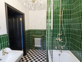 A bathroom with a bathtub, sink, and tiles at Holly Farm near Brantham