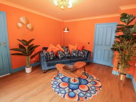 A living room with a blue sofa and round coffee table at Holly Farm near Brantham