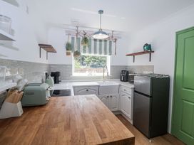 A kitchen with appliances and a window at Holly Farm near Brantham
