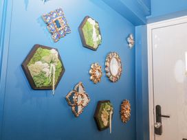 A wall with decorative mirrors and moss displays at Holly Farm near Brantham