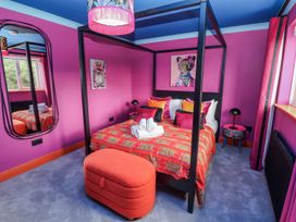 A bedroom with a four-poster bed and decorative items at Holly Farm near Brantham