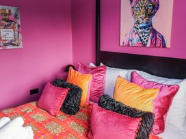 A bedroom with colorful pillows and wall art at Holly Farm near Brantham