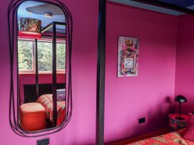 A bedroom with a mirror and colorful decor at Holly Farm near Brantham