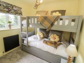 A bedroom with a bunk bed and decorative pillows at Holly Farm near Brantham