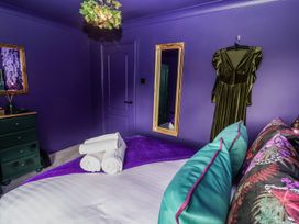 A bedroom with a bed and a mirror at Holly Farm near Brantham