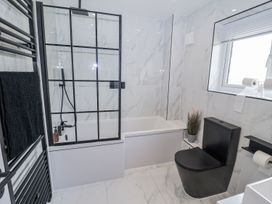 A bathroom with a bathtub and shower at Holly Farm near Brantham