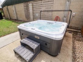A hot tub with a step stool outside at Holly Farm near Brantham