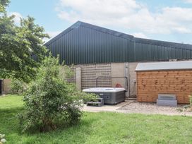A garden with a hot tub and a shed at Holly Farm near Brantham