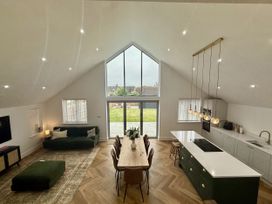 A living room with a sofa, dining table and kitchen island at Bader House in Ipswich