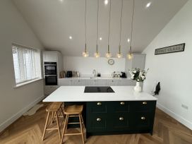 A kitchen with an island and stools at Bader House in Ipswich