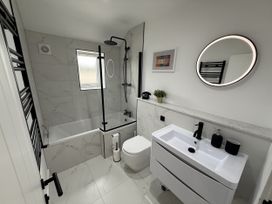 A bathroom with bathtub, sink, and toilet at Bader House, Ipswich