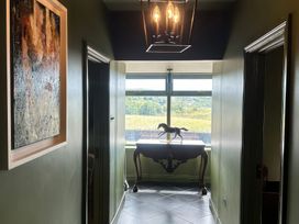 A hallway with a table and statue at The Garden Cottage and Carriage House Annagry, County Donegal