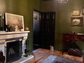 A living room with a fireplace and paintings at The Garden Cottage and Carriage House in Annagry, County Donegal
