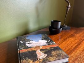 A book on a table with a sculpture and bowls at The Garden Cottage and Carriage House in Annagry, County Donegal