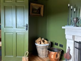 A sitting room with a door and a fireplace at The Garden Cottage and Carriage House Annagry, County Donegal