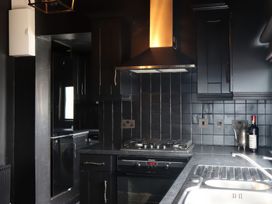 A kitchen with cabinets, stove, oven, and sink at The Garden Cottage and Carriage House, Annagry, County Donegal