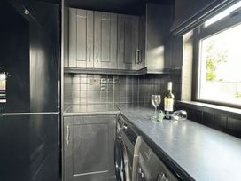 A kitchen with a refrigerator and wine bottle at The Garden Cottage and Carriage House Annagry, County Donegal