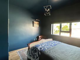A bedroom with a bed and a chair at The Garden Cottage and Carriage House in Annagry, County Donegal