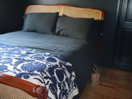 A bed with dark bedding and pillows at The Garden Cottage and Carriage House Annagry, County Donegal