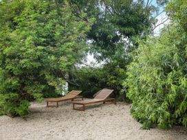 Two lounge chairs in a garden surrounded by trees at The Garden Cottage and Carriage House in Annagry, County Donegal