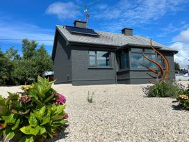 A house with a solar panel and sculpture in the garden at The Garden Cottage and Carriage House Annagry, County Donegal