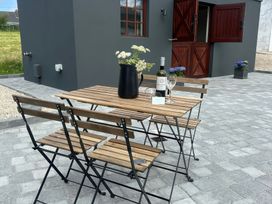 A table with chairs and a wine bottle at The Garden Cottage and Carriage House in Annagry, County Donegal