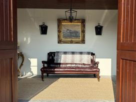 An outdoor sitting area with a sofa and artwork at The Garden Cottage and Carriage House Annagry, County Donegal