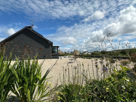 A garden area with a house and outdoor furniture at The Garden Cottage and Carriage House in Annagry, County Donegal