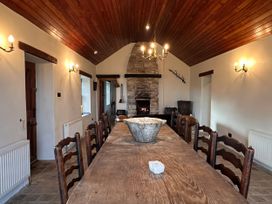 A dining room with a wooden table and chairs at Cobble Stone Cottage near Leabgarrow, County Donegal