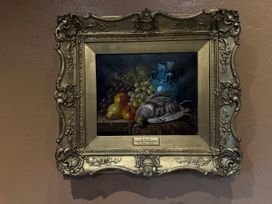 A painting of fruit and a bird in a frame at Cobble Stone Cottage near Leabgarrow, County Donegal