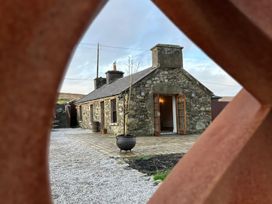 A stone cottage with open doors and gravel path at Cobble Stone Cottage near Leabgarrow, County Donegal