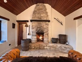 A living room with a stone fireplace and wooden features at Cobble Stone Cottage near Leabgarrow, County Donegal