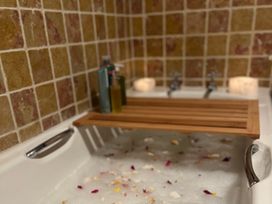 A bathtub with bath oils and candles at Cobble Stone Cottage near Leabgarrow, County Donegal