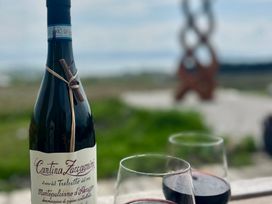 A bottle of wine and glasses on a table at Cobble Stone Cottage near Leabgarrow, County Donegal