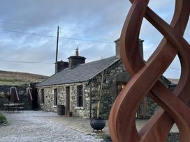A house with a sculpture in the garden at Cobble Stone Cottage near Leabgarrow, County Donegal