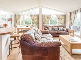A living room with a sofa and dining area at 2 Tree Tops in Lanreath
