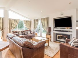 A living room with a sofa and television at 2 Tree Tops in Lanreath